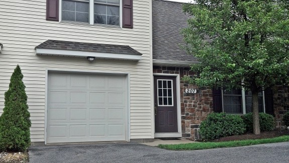 Exterior of townhouse with garage, siding, and brick exterior