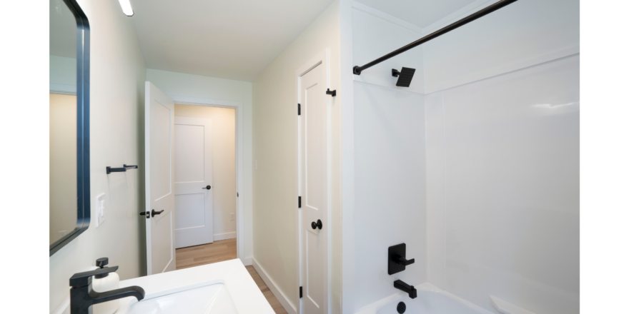 a bathroom with a sink, mirror and bathtub