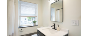 a bathroom with a sink, toilet, and window