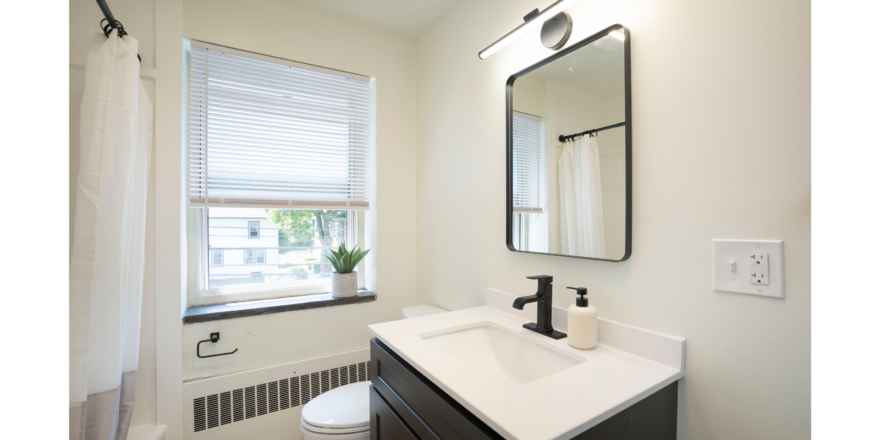 a bathroom with a sink, toilet, and window