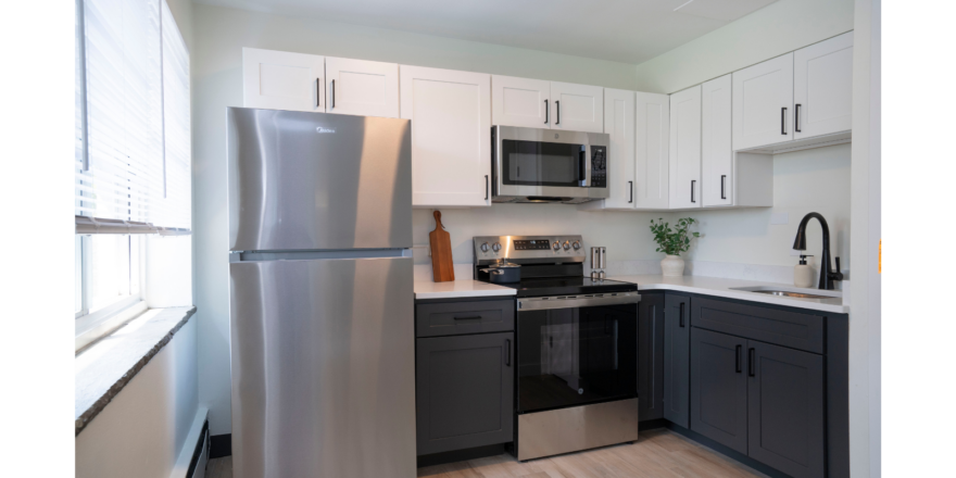 a kitchen with a silver refrigerator freezer next to a window