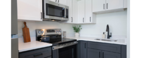 a kitchen with white cabinets and black appliances