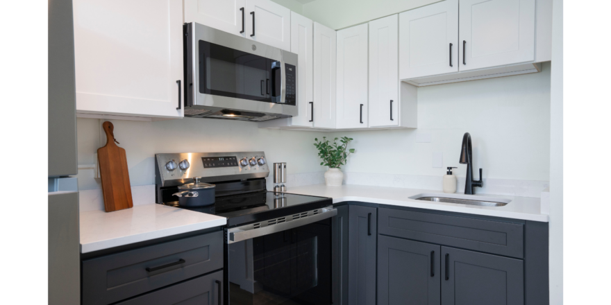 a kitchen with white cabinets and black appliances