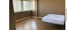 an empty bedroom with a bed and a window