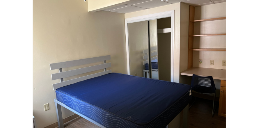 a bed sitting in a bedroom next to a book shelf