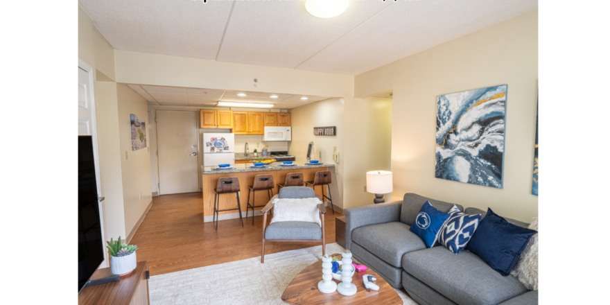 a living room filled with furniture and a kitchen