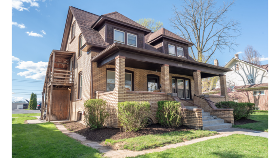 a brown brick house with two story windows