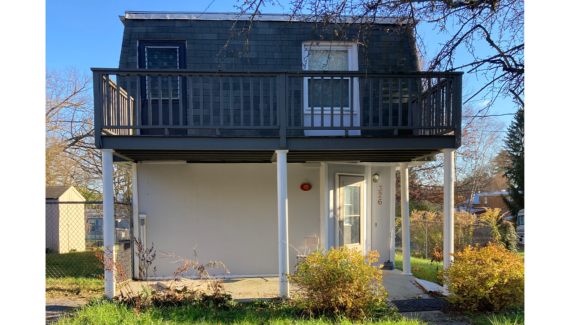 a small house with a balcony on the second floor