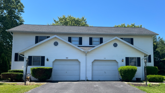 a white two story duplex with black shutters