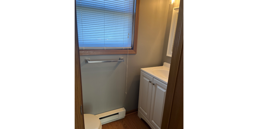a bathroom with a toilet, sink and a window