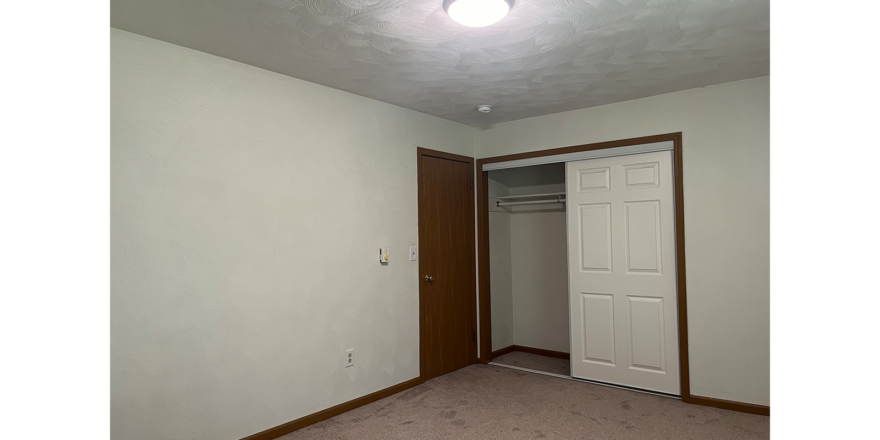 an empty room with a closet and a door