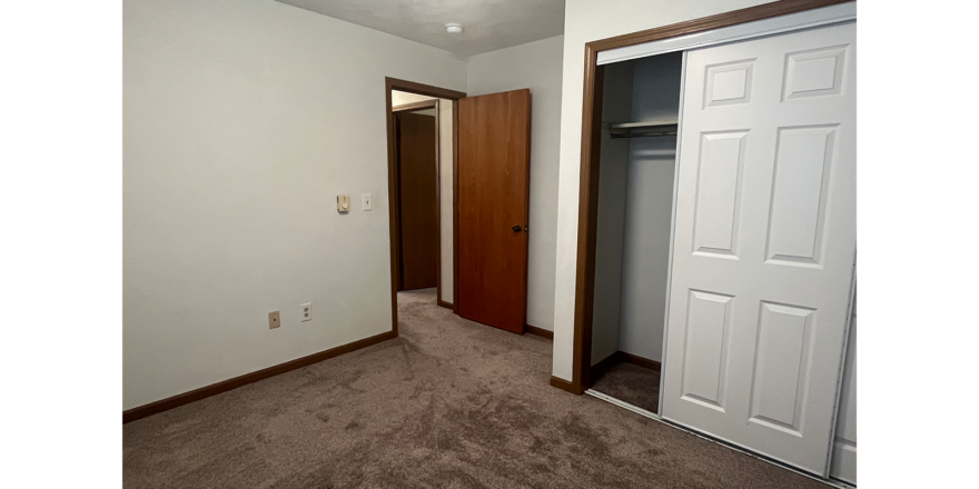 an empty room with a closet and a closet door
