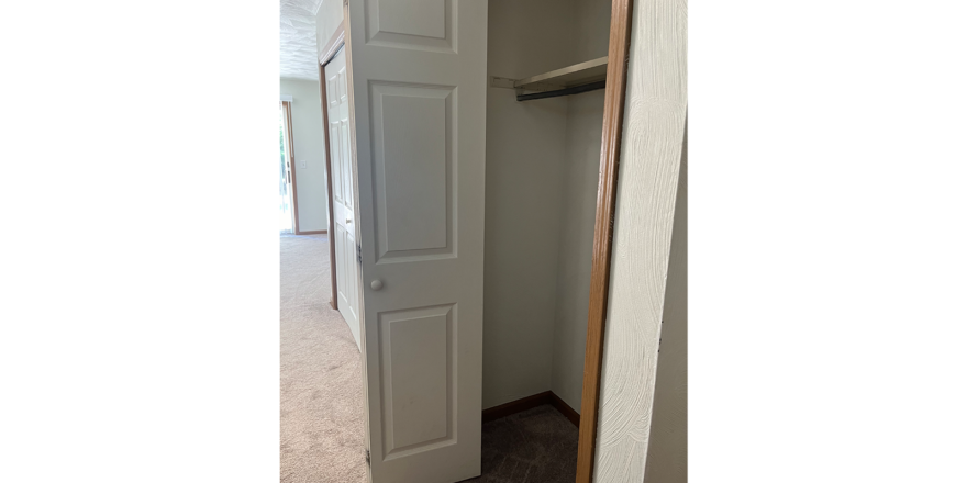 an empty closet with a door open