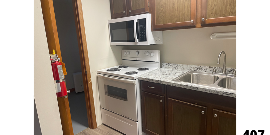 a kitchen with a sink, stove and microwave