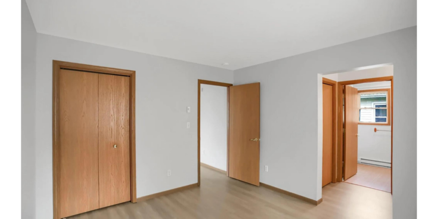 an empty room with wooden doors and a hard wood floor