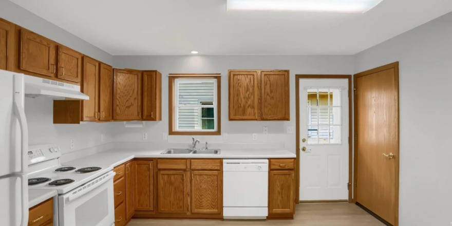 a kitchen with white appliances and wooden cabinets