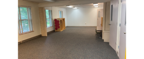 an empty room with gray carpet, white walls, and 2 windows