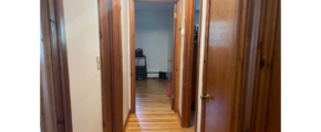 a hallway with wooden doors and hard wood floors