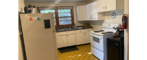 a kitchen with a refrigerator, stove, and sink