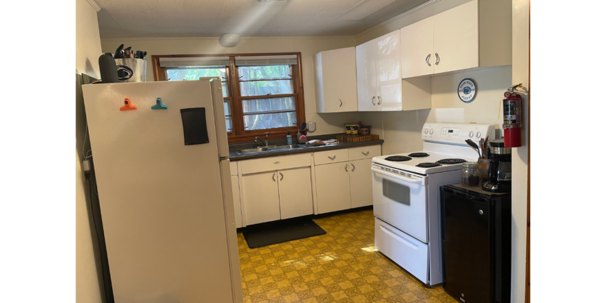 a kitchen with a refrigerator, stove, and sink