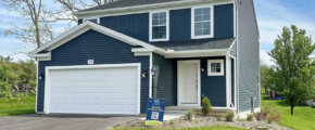 a two story house with blue siding and a white garage