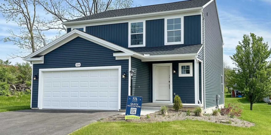 a two story house with blue siding and a white garage