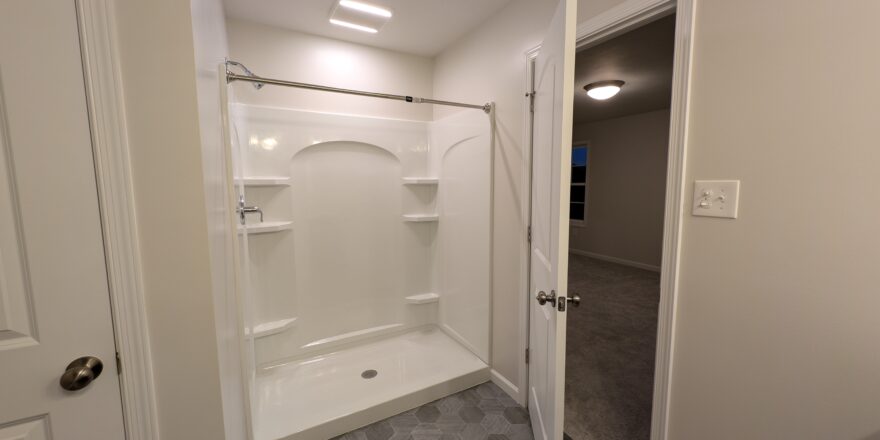 a bathroom with a walk in shower next to a door