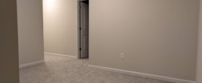 an empty room with carpet and a door