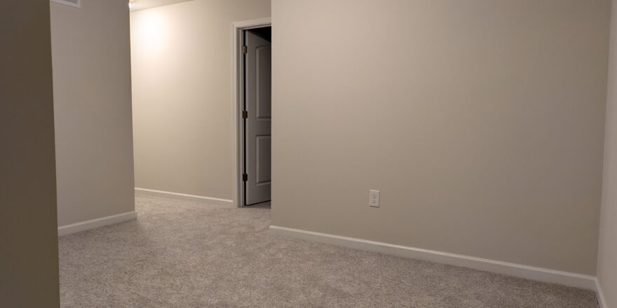 an empty room with carpet and a door