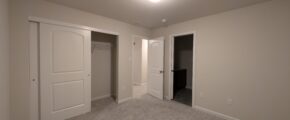 an empty room with two doors and a closet