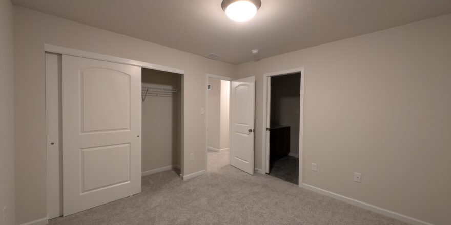 an empty room with two doors and a closet