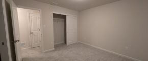 an empty room with a door and a closet