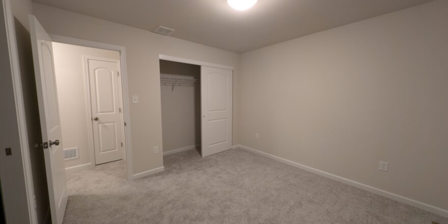 an empty room with a door and a closet