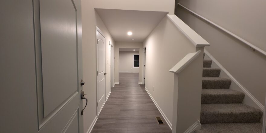 a long hallway with stairs leading to another room