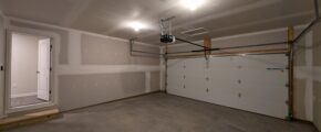 an empty garage with a white door and a window