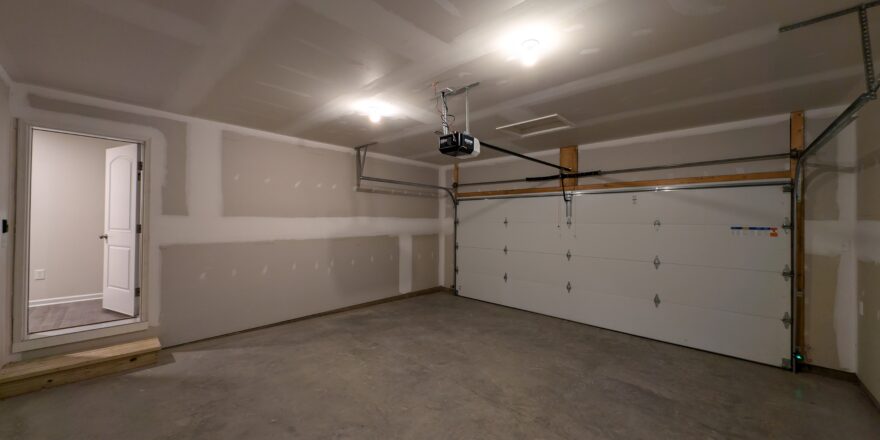 an empty garage with a white door and a window