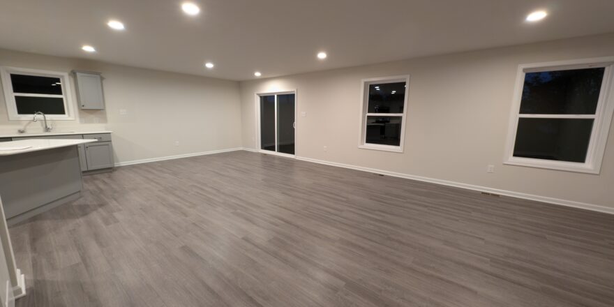 an empty room with a counter, cabinets, and windows