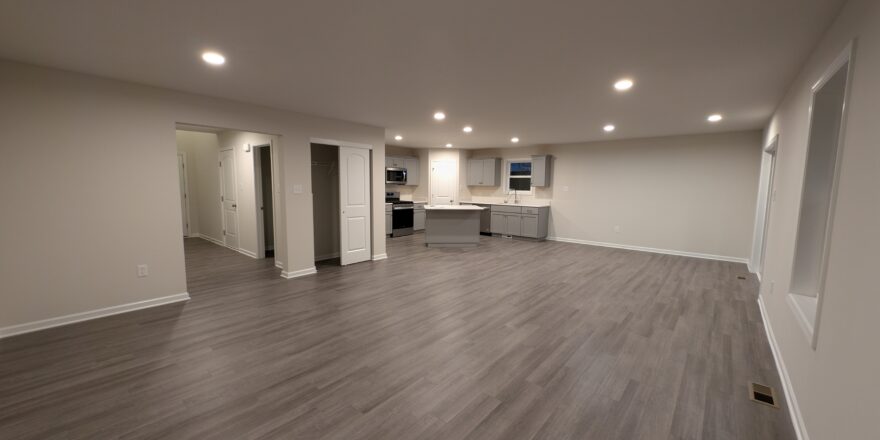 an empty living room with hard wood floors