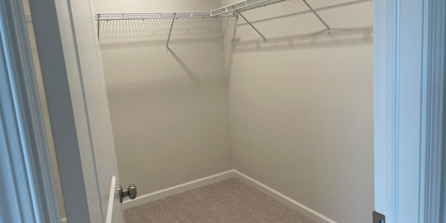 a walk in closet with a closet door open