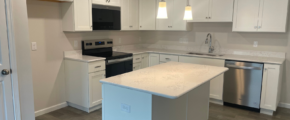 a kitchen with white cabinets and stainless steel appliances