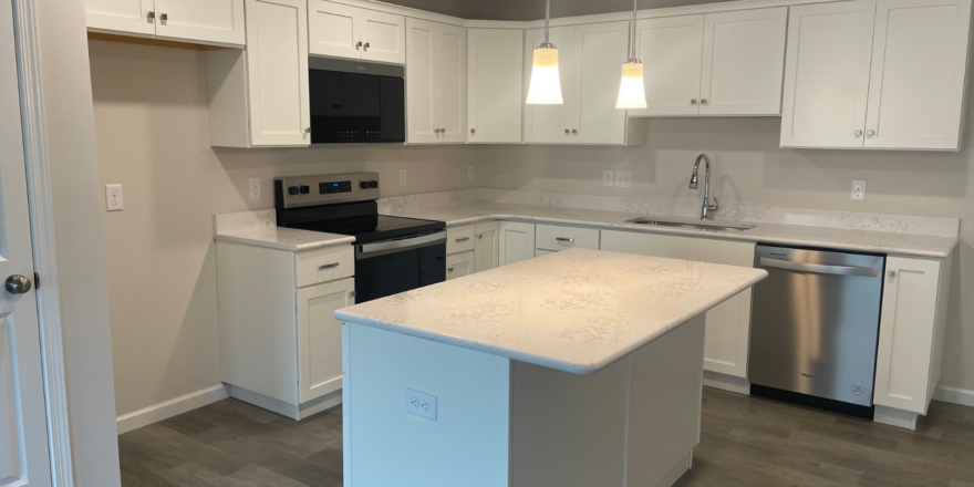 a kitchen with white cabinets and stainless steel appliances