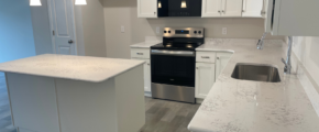 a kitchen with white cabinets and a black stove top oven