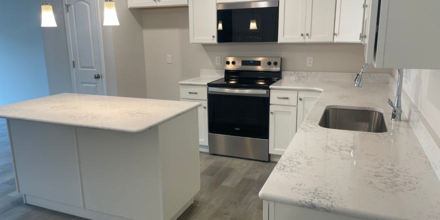 a kitchen with white cabinets and a black stove top oven